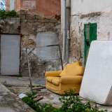 Ci avviciniamo dunque ai caseggiati, dove ad accoglierci ci sono un divano giallo e un materasso appoggiati a una parete...